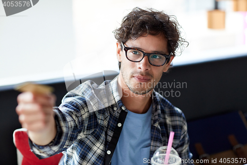 Image of happy man paying with credit card at cafe