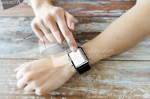 Image of close up of hands with coding on smart watch