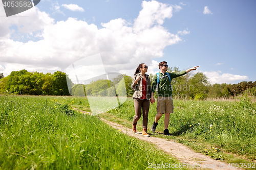 Image of happy couple with backpacks hiking outdoors