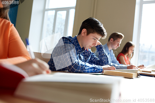 Image of group of students with books writing school test