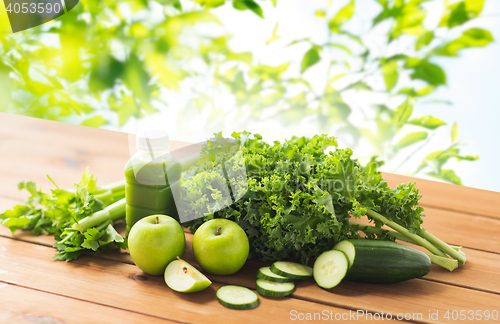 Image of close up of bottle with green juice and vegetables