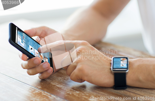 Image of close up of hands with smart phone and watch