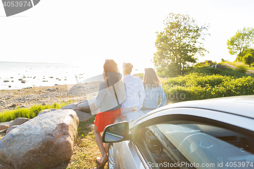 Image of happy teenage girls or women near car at seaside
