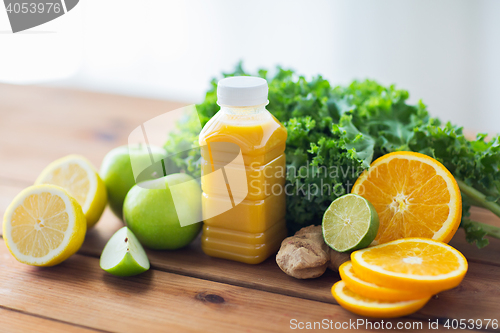 Image of bottle with orange juice, fruits and vegetables