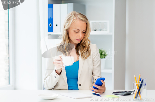 Image of businesswoman texting on smartphone at office