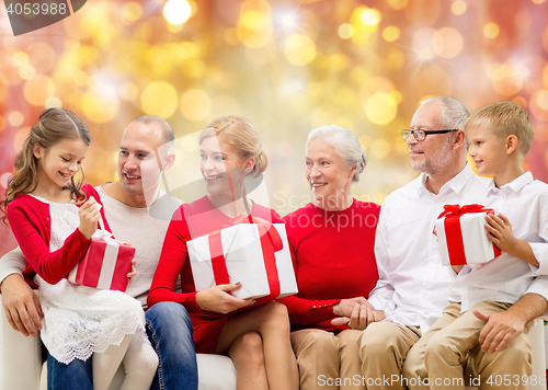 Image of happy family with christmas gifts over lights