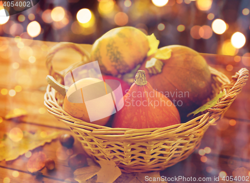 Image of close up of pumpkins in basket on wooden table