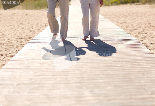 Image of close up of senior couple walking on summer beach