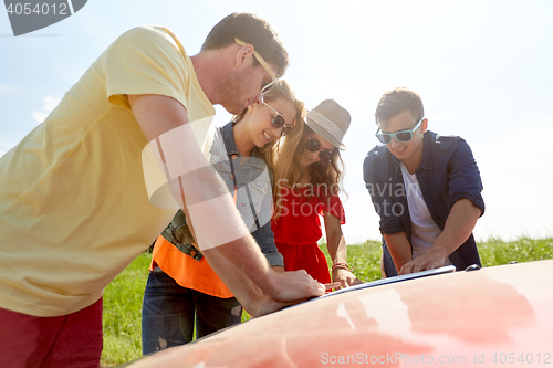 Image of happy friends with map and car searching location