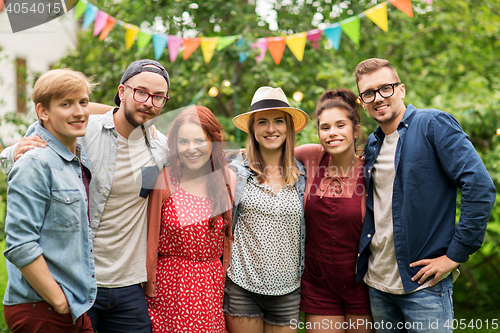 Image of happy teenage friends hugging at summer garden