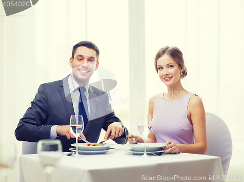 Image of smiling couple eating appetizers at restaurant