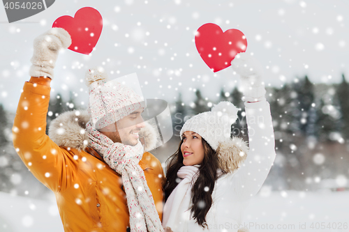 Image of happy couple with red hearts over winter landscape