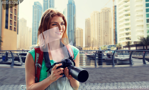 Image of woman with backpack and camera over dubai city