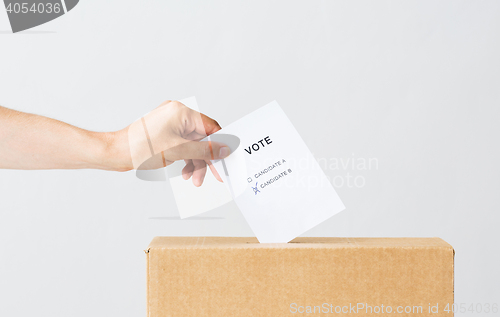 Image of man putting his vote into ballot box on election