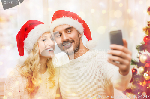 Image of couple taking selfie with smartphone at christmas