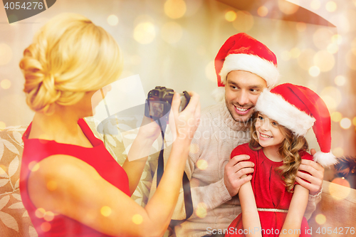 Image of mother taking picture of father and daughter