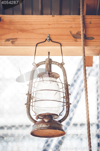 Image of Vintage western lantern hanging on a wooden plank