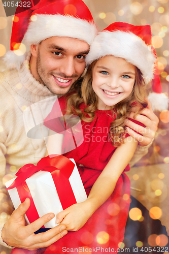 Image of smiling father and daughter holding gift box