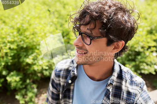 Image of close up of smiling man in eyeglasses outdoors