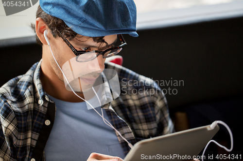 Image of close up of man with tablet pc and earphones