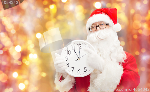 Image of man in costume of santa claus with clock