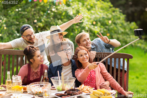 Image of friends taking selfie at party in summer garden