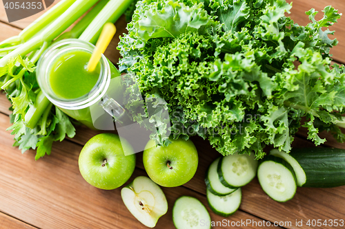 Image of close up of jug with green juice and vegetables