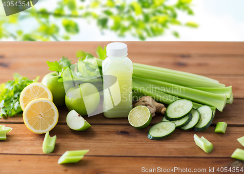 Image of close up of bottle with green juice and vegetables