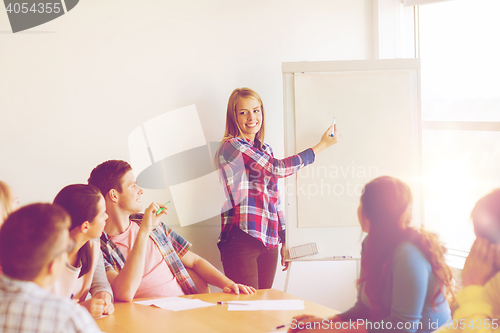 Image of group of smiling students with flip board