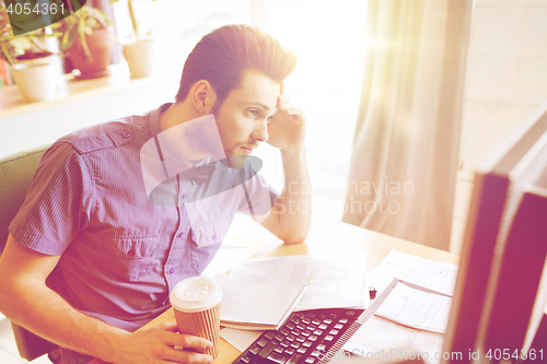 Image of creative male worker with computer drinking coffee