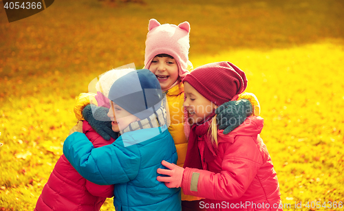 Image of group of happy children hugging in autumn park