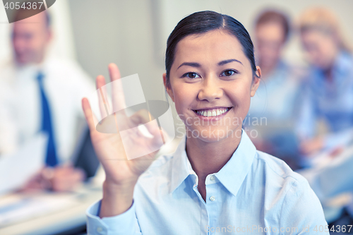 Image of group of smiling businesspeople meeting in office