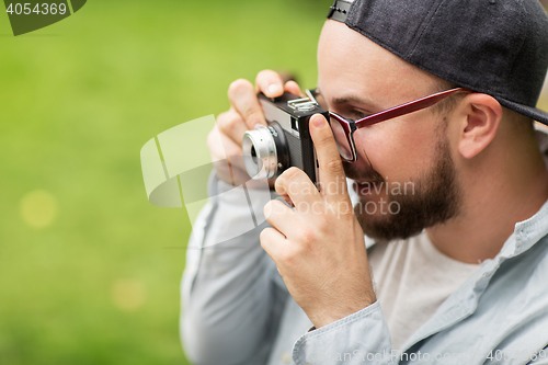 Image of close up of man with camera shooting outdoors