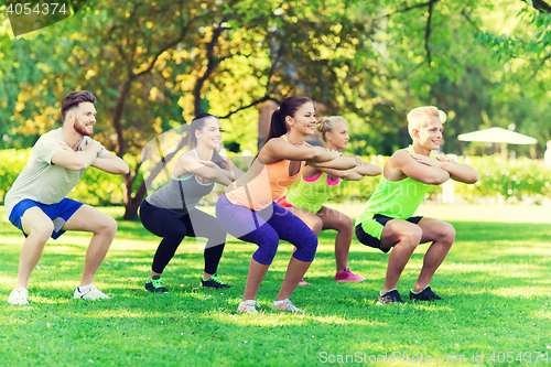 Image of group of friends or sportsmen exercising outdoors