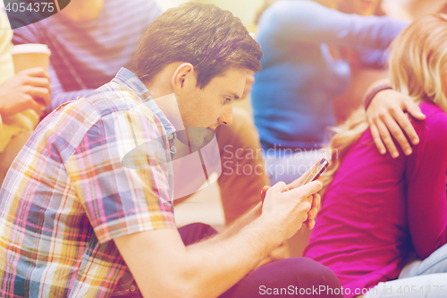 Image of group of smiling students with smartphone