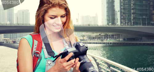 Image of woman with backpack and camera over dubai city