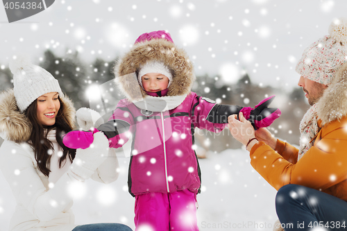 Image of happy family with child in winter clothes outdoors