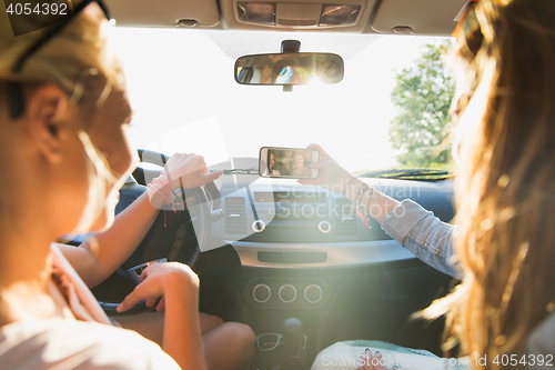 Image of teenage girls or women with smartphone in car