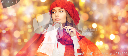 Image of happy woman in winter clothes with shopping bags