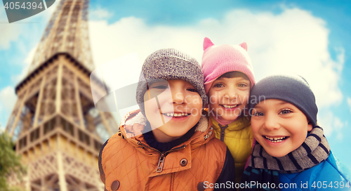 Image of group of happy children hugging over eiffel tower