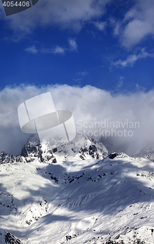 Image of Mount Ushba in clouds at sun winter day