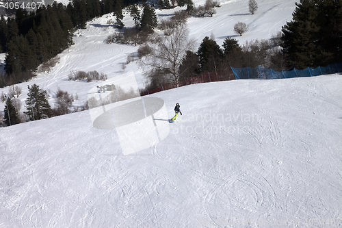 Image of Snowboarder on ski slope at sun winter day