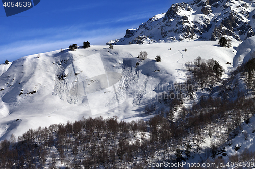 Image of Off-piste slope with track from avalanche on sun day