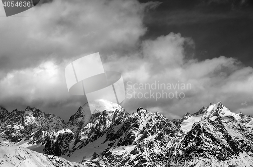 Image of Black and white view on snow mountaims in clouds at sun winter d