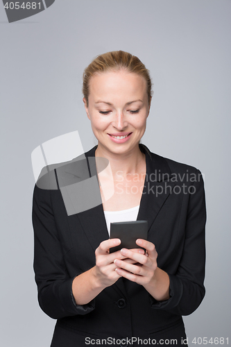 Image of Beautiful young caucasian businesswoman using mobile phone.