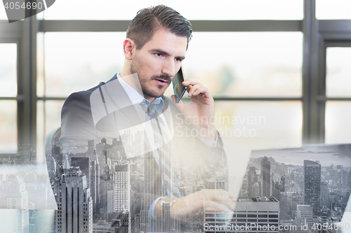 Image of Businessman in office working on laptop computer.