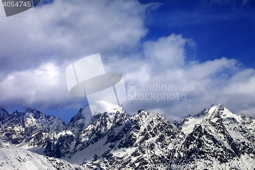 Image of Snow mountaims in clouds at sun winter day