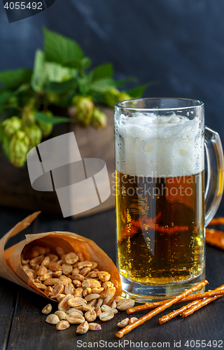 Image of Mug of beer, peanuts and straws.