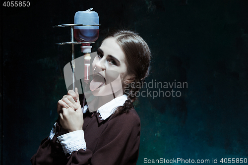 Image of Portrait of a young girl in school uniform as a vampire woman