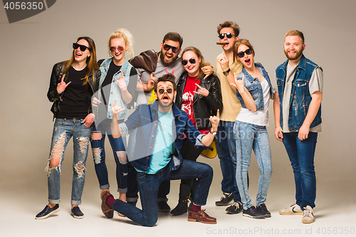 Image of Group of happy young friends in blue jeans
